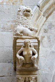 Croatia, Dalmatia, Korcula Island, Korcula Town, detail of the central portal of the St. Mark's Cathedral, sculpture of Eve under a lion on the main facade
