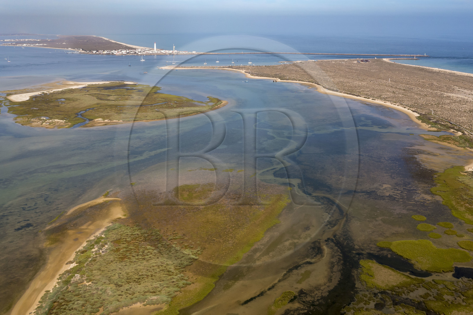 Portugal, Algarve, Ria Formosa Natural Park, Faro, Island of Barreta or Deserta (Ilha da Barretta or Deserta), the lighthouse of Ilha do Farol part of  Ilha da Culatra in the background (aerial view)