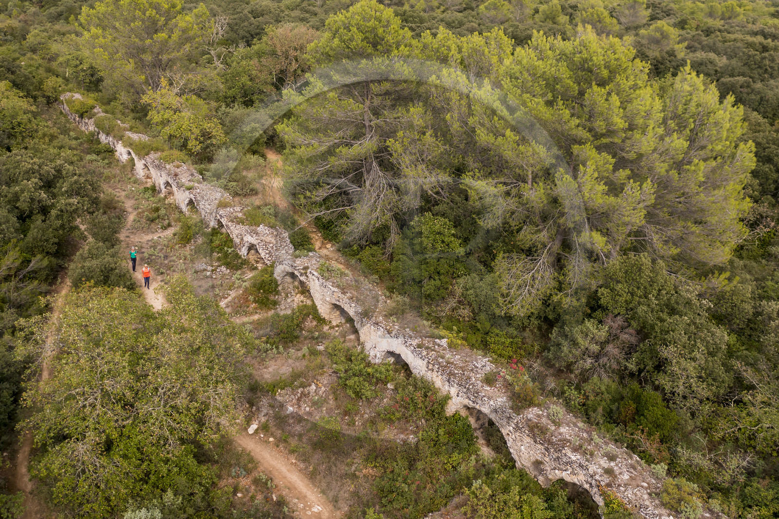 France, Gard (30), Vers-Pont-du-Gard, randonneurs longeant les vestiges de l'aqueduc romain de plus de 52 km de longueur qui amenait l'eau de la Fontaine d'Eure au pied d'Uzès jusqu'à Nimes en passant sur le Pont du Gard  (vue aérienne)