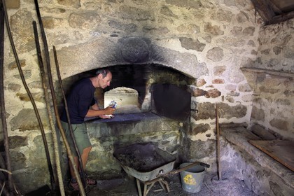 France, Cantal (15), Parc naturel régional de l'Aubrac, hameau de Le Laussier à Lieutades, le guide naturaliste et aquarelliste Thierry Ballay dans la maison de famille, le four à pain du XVIIIe siècle
