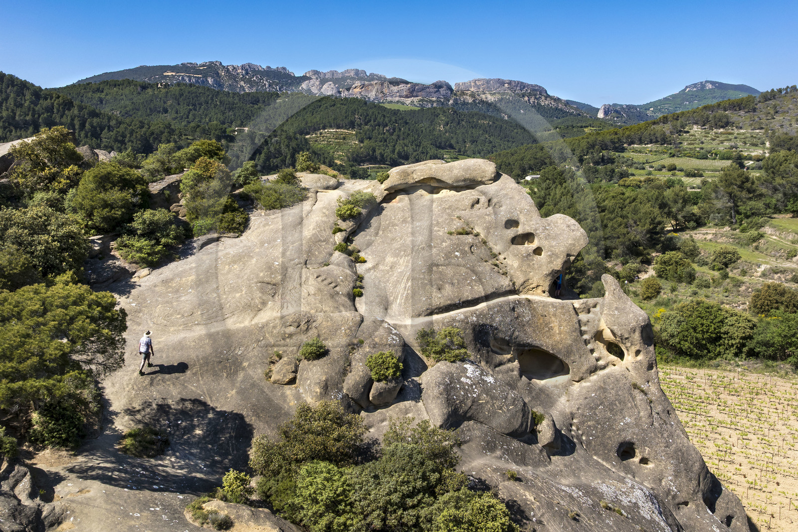 France, Vaucluse (84), Dentelles de Montmirail, Beaumes-de-Venise, le Rocher Rocalinaud, curiosité géologique en grès et habitat troglodytique du néolithique au moyen-âge, les Dentelles Sarrasines et la montagne du Clapis en arrière plan (vue aérienne)