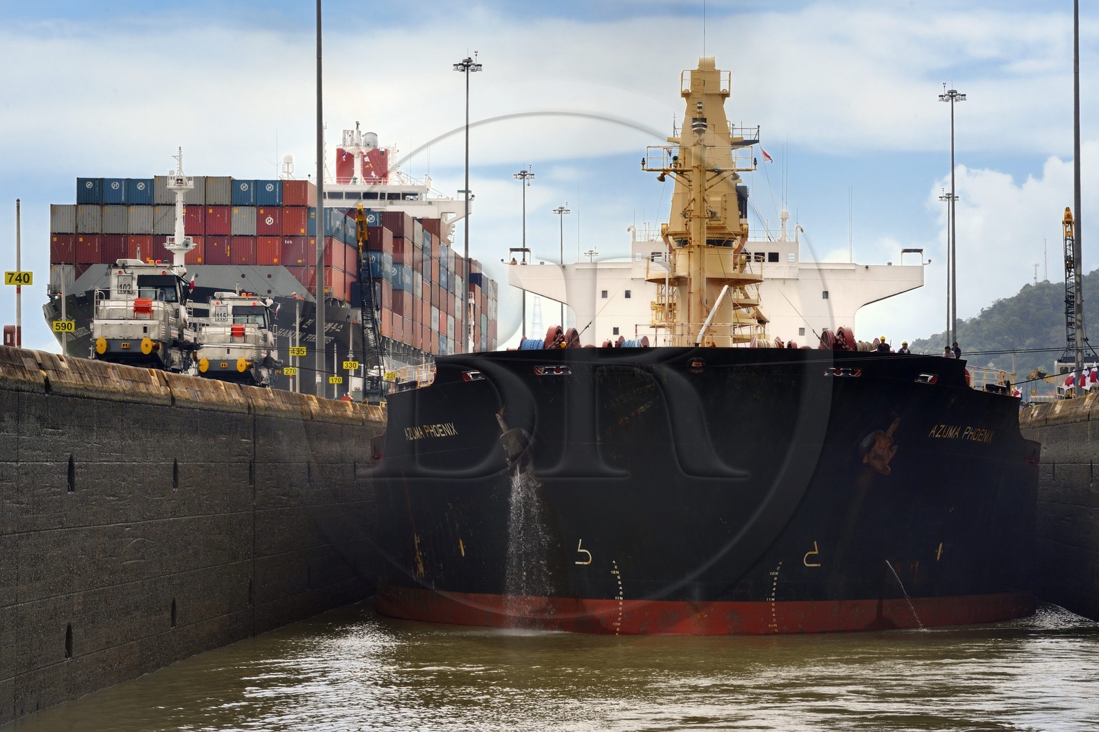 Panama, Canal de Panama, écluses de Miraflores, mules mécaniques ou locomotives électriques guidant un cargo Panamax entre les murs de l'écluse