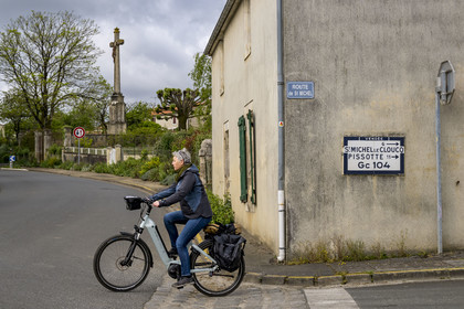 France, Vendée (85), Xanton–Chassenon, cycliste sur la piste de la véloroute Vendée Vélo Tour et plaque Michelin, signaux routier ancien donnant la direction de Pissote et Saint-Michel-le-Cloucq
