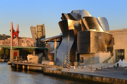 Spain, Basque Country Region, Vizcaya Province, Bilbao, the Guggenheim Museum designed by Frank Gehry and the Salve bridge with Les Arches Rouges artpiece by French artist Daniel Buren in the background