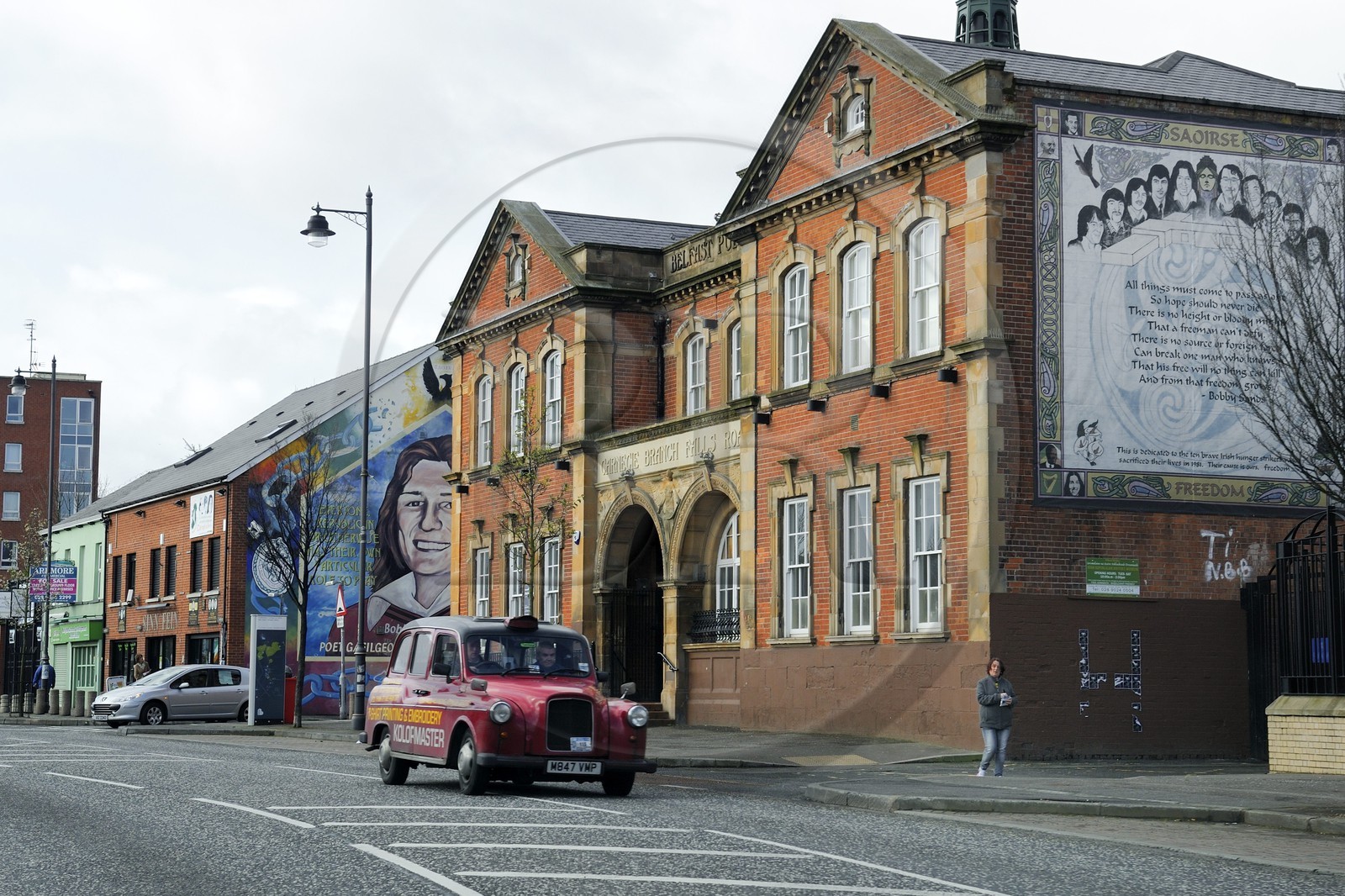 United Kingdom, Northern Ireland, West Belfast, Catholic Falls area, murals on Falls Road and headquarters of the Sinn Fein in the background