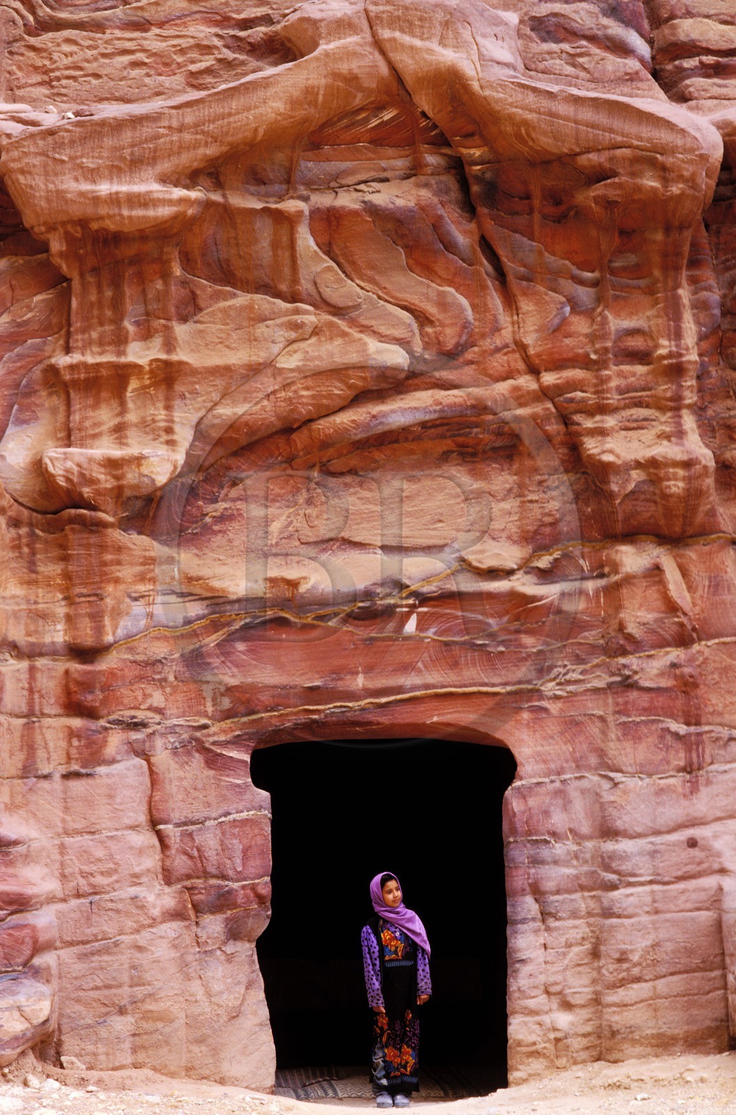 Jordan, Petra, a young Bedouin in front of tomb's frontage