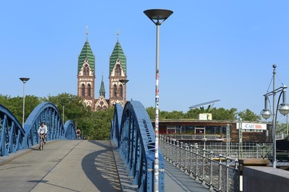 Allemagne, Bade-Wurtemberg, Fribourg en Brisgau, cycliste sur le pont bleu (pont Wiwili) , l'église du Sacré-Coeur de Jésus (Herz-Jesu-Kirche) et la station à vélos Mobile à droite en arrière-plan