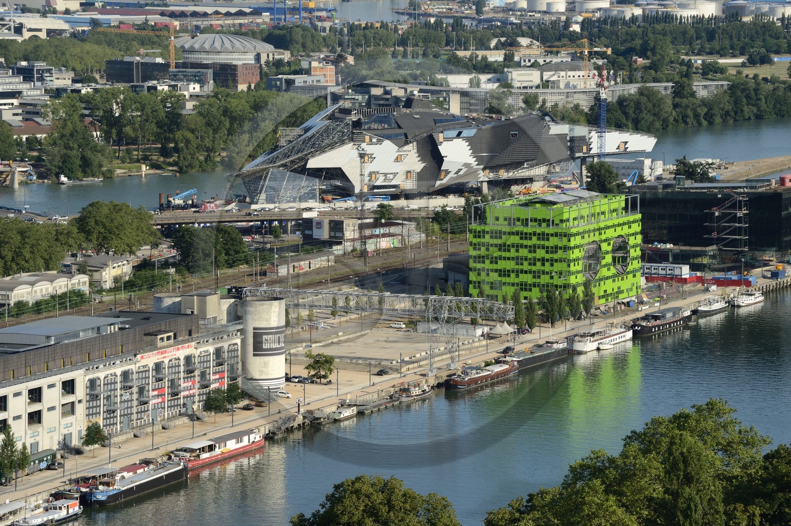 France, Rhône (69), Lyon, nouveau quartier de La Confluence au sud de la Presqu'île, Quai Rambaud, la Sucrière ancien entrepôt des années 1930 accueille depuis 2003 la biennale d'art contemporain et en arrière plan sur la droite le batiment vert siège d'Euronews et le chantier du futur musée des Confluences