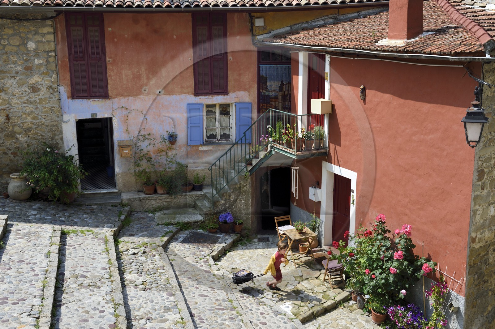 France, Alpes-Maritimes (06), Coaraze, labellisé Les Plus Beaux Villages de France, enfant partant à l'école dans les rues en escalier
