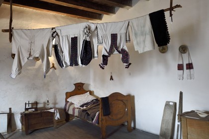 Roumanie, Transylvanie, Hunedoara, le chateau de Hunedoara ou chateau des Corvins, pièce avec meubles et vêtements traditionnels du XIXème siècle