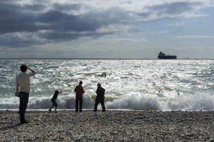 France, Seine-Maritime (76), Le Havre, cargo quittant le port du Havre vu de la plage de la ville