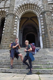 France, Haute-Loire (43), Le Puy-en-Velay, un couple de pélerins en partance sur le chemin de Compostelle devant porche de la cathédrale Notre-Dame-de-l'Annonciation du XIIe siècle classée Patrimoine Mondial de l'UNESCO