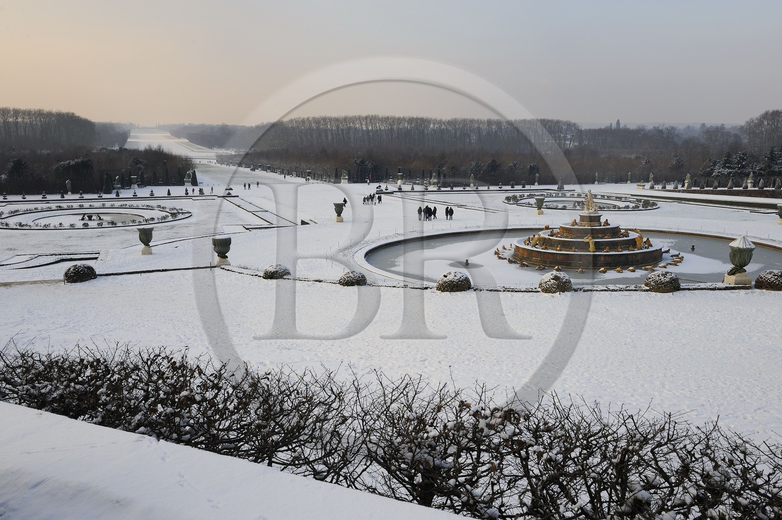 France, Yvelines, snow covered park of the Chateau de Versailles, listed as World Heritage by UNESCO, the Latona Basin and gardens perspective and the Axe du Soleil (the Sun Axis) to the frozen Grand Canal