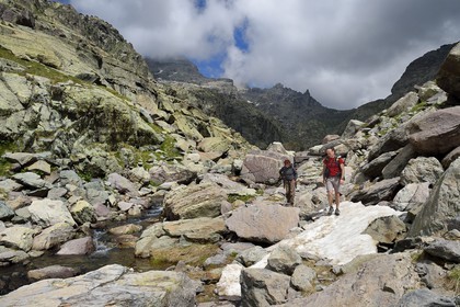 France, Alpes-Maritimes, parc national du Mercantour (Mercantour National Park), the Vallee des Merveilles (Valley of Wonders) scattered with thousands of rupestral engravings of the Bronze Age, hikers on the trail GR 52 towards the Baisse (pass) de Valmasque and the Mont Grand Capelet (2915 m) in the background