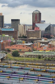 Afrique du Sud, province de Gauteng, Johannesburg, les wagons de trains colorés de Park Station et le centre-ville vus depuis le quartier de Braamfontein