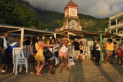 Caraïbes, Ile de la Dominique, baie de Soufrière, le village de Soufrière, bar à rhum sur la plage et l'église catholique de Saint-Marc en arrière plan