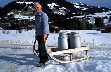 Suisse, région de Bern (Oberland Bernois), Saanenland, Gstaad, paysan tractant du lait sur une luge