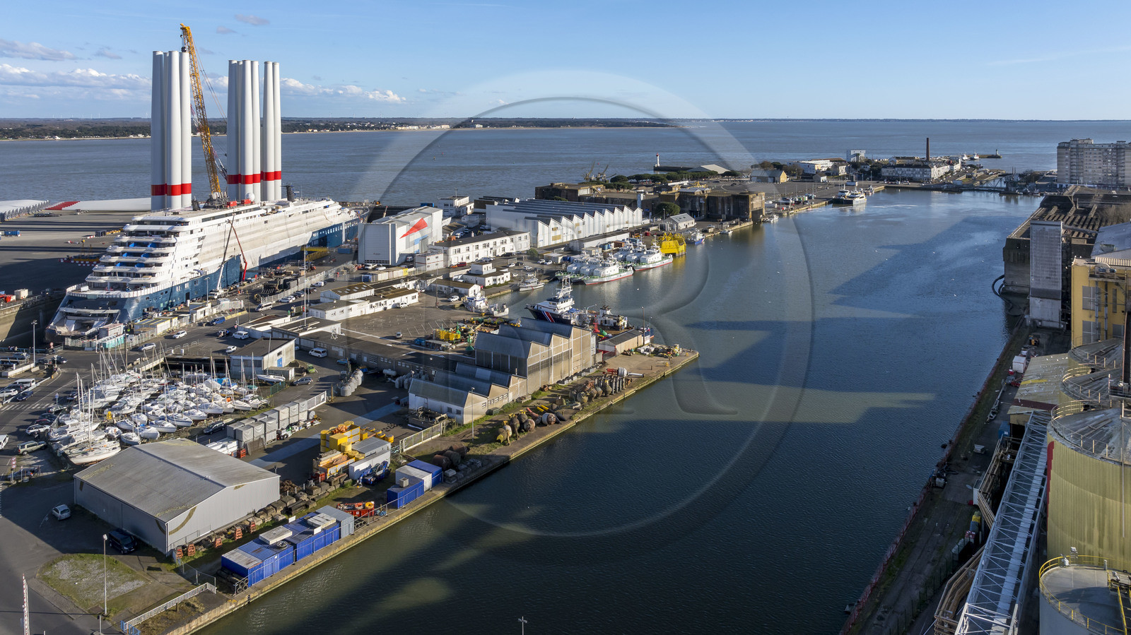 France, Loire-Atlantique (44), Saint-Nazaire, le chantier du super-yacht de luxe Ritz-Carlton Luminara dans la forme Joubert, les tours d'éoliennes à coté sont stockées avant embarquement (vue aérienne)