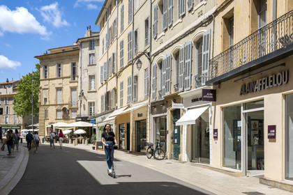 France, Bouches-du-Rhône (13), Aix en Provence, rue Thiers, femme sur une trottinette éléctrique