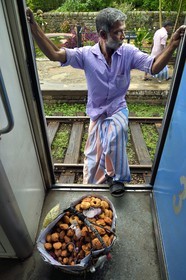 Sri Lanka, Province du Centre, trajet en train dans la région montagneuse de la culture du thé entre Hatton et Ella, gare de Talawakele, vendeur ambulant de beignets de crevettes et de wade