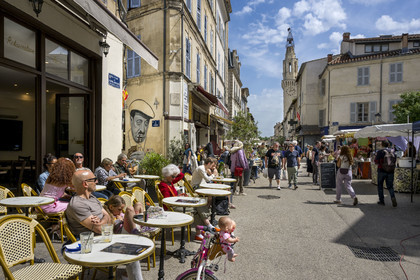 France, Vaucluse (84), Avignon, terrasses de café sur la place du Portail Matheron un jour de marché, un portrait de Raimu lors de la partie de cartes du film Marius de Marcel Pagnol par l'artiste graffeur Lekto, le clocher des Augustins en arrière plan