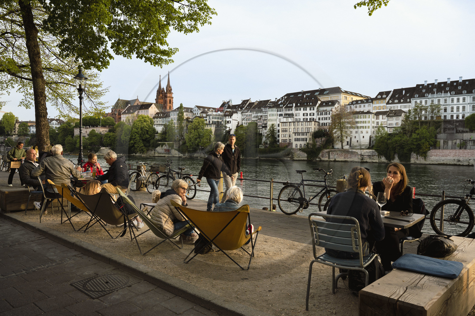 Suisse, Bâle, les quais du quartier du Petit Bâle sur la rive droite du Rhin et la cathédrale protestante Notre-Dame de Bâle (Munster) en arrière plan, terrasses de restaurants et cafés s'animent à la tombée du soir