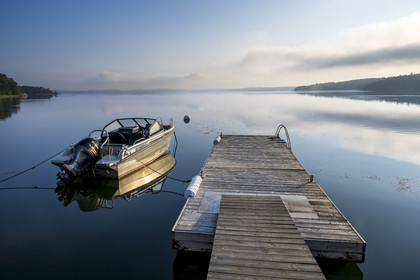 Suède, Archipel de Stockholm, station balnéaire de Saltsjöbadens, bateau amarré à un ponton au petit matin