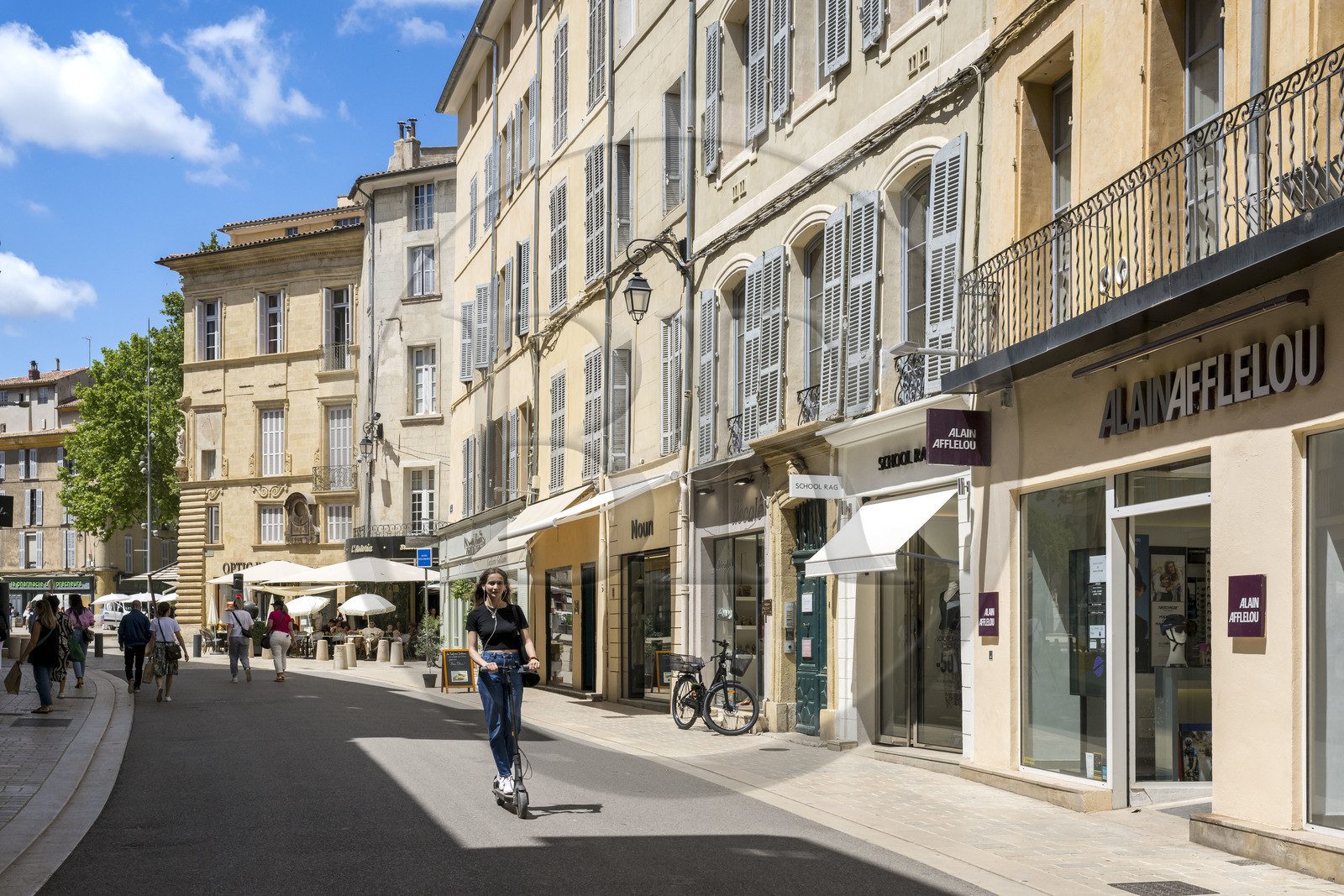 France, Bouches-du-Rhône (13), Aix en Provence, rue Thiers, femme sur une trottinette éléctrique