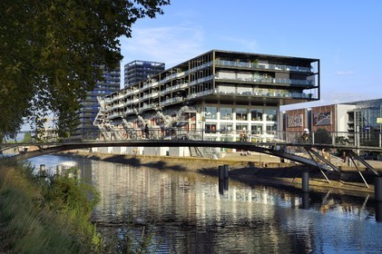 France, Bas-Rhin (67), Strasbourg, amenagement du port du Rhin et reconversion du mole du Bassin d'Austerlitz, presqu'ile Malraux, ancien entrepot du Mole Seegmuller transformé en commerce et appartements d'habitation en bordure du bassin d'Austerlitz, les immeubles les Black Swans en arrière plan