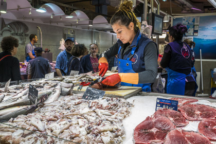 France, Hérault (34), Sète, Les Halles, marché couvert, Carla prépare le poisson à l'étal du poissonnier Chez Cyril
