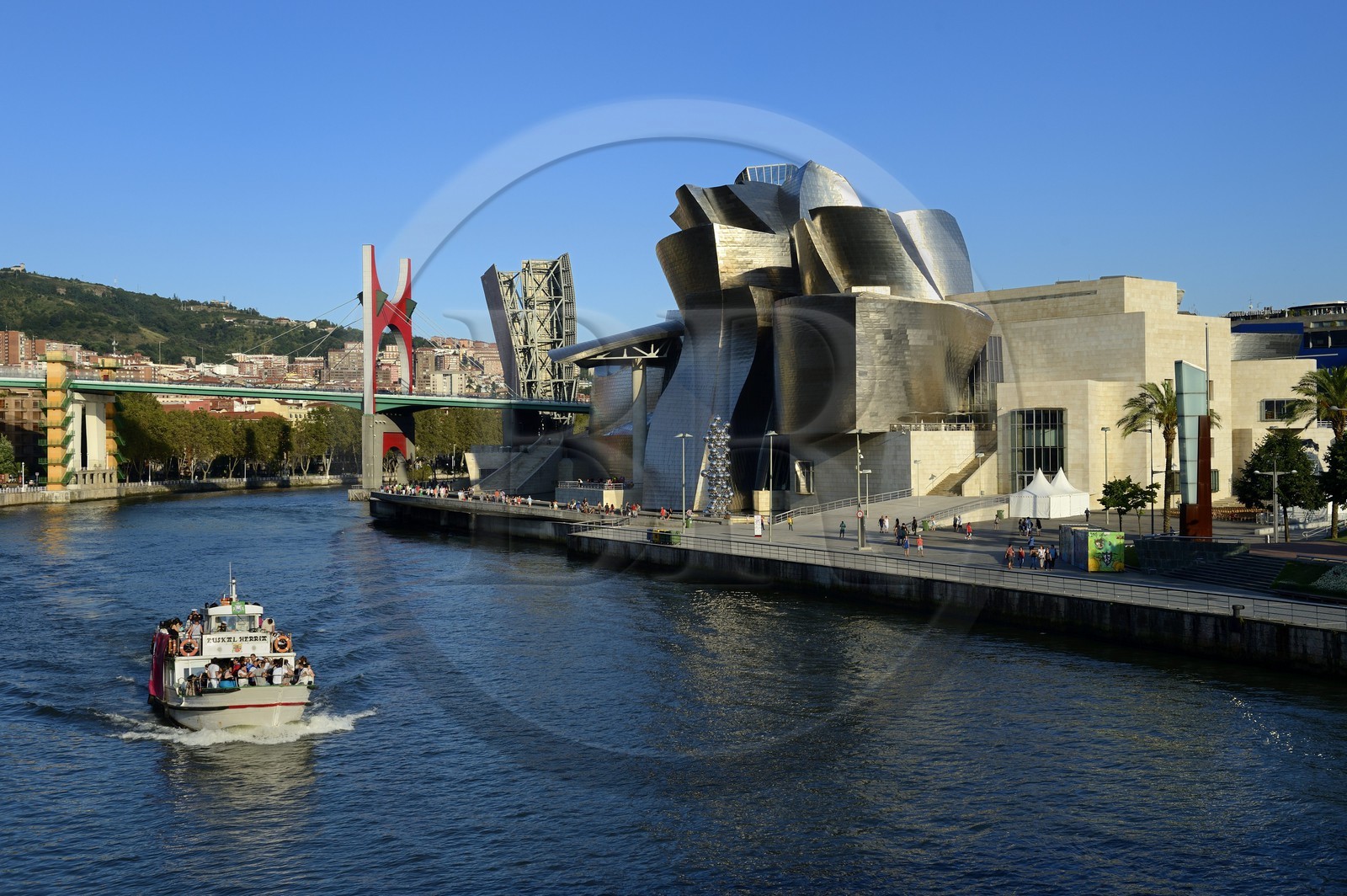 Spain, Basque Country Region, Vizcaya Province, Bilbao, the Guggenheim Museum designed by Frank Gehry and the Salve bridge with Les Arches Rouges artpiece by French artist Daniel Buren in the background