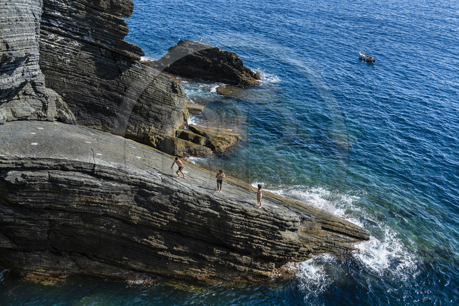 Italie, Ligurie, Cinque Terre, parc national des Cinque Terre classé Patrimoine Mondial de l'UNESCO, village de Vernazza, jeunes gens plongeant d'un rocher au pied du village