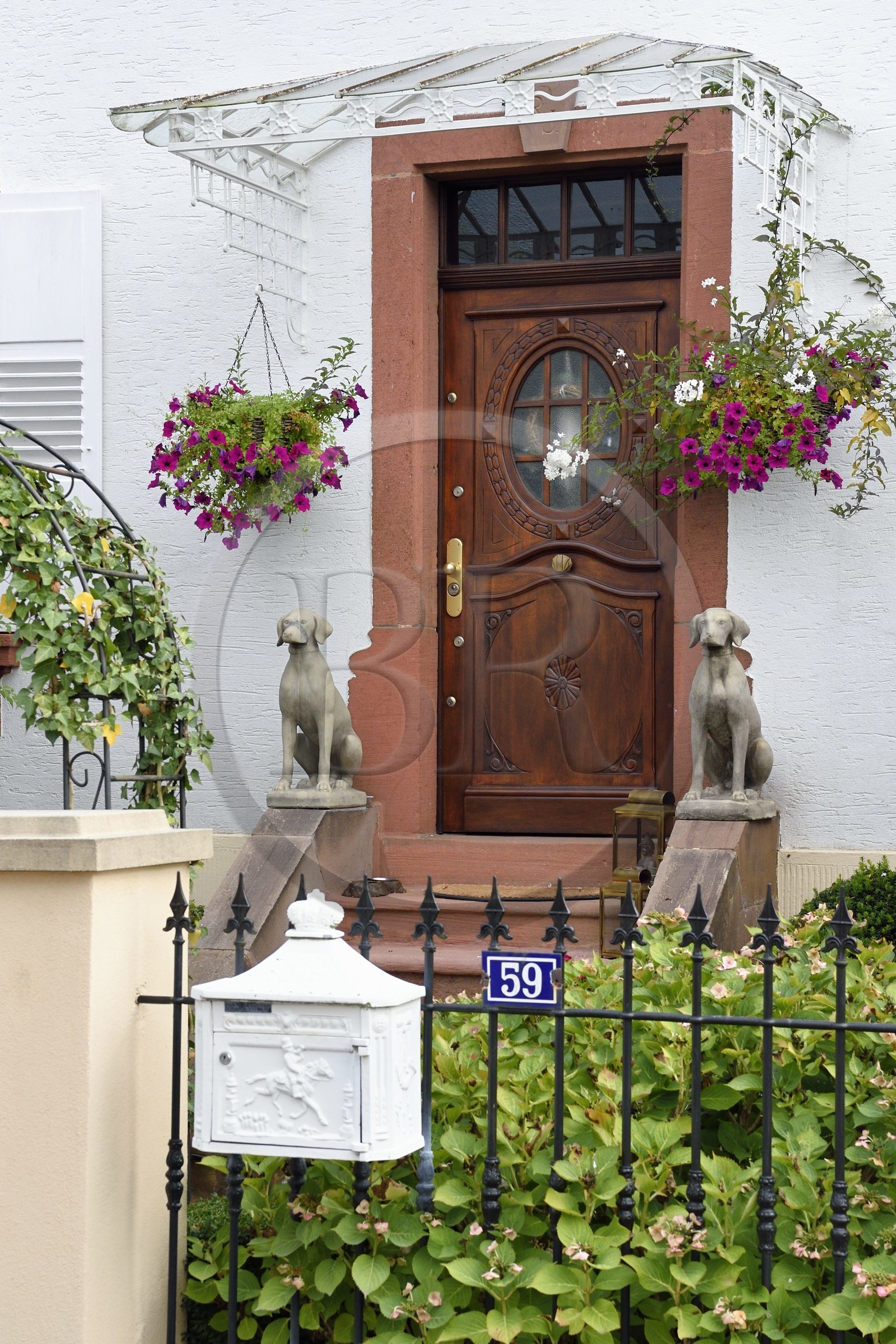 France, Bas Rhin, Northern Vosges Regional Natural Park, Obersteinbach, guard dogs statues in front of a house