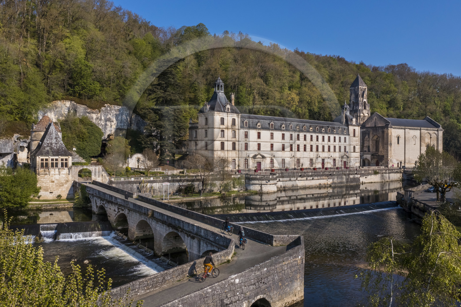 France, Dordogne (24), Brantôme, cyclistes faisant la véloroute la Flow Vélo traversant le Pont Coudé sur la Dronne, l’abbaye bénédictine Saint-Pierre de Brantôme en arrière plan (vue aérienne)