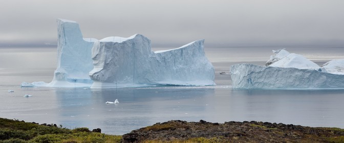 Groenland, cote ouest, Ile de Disko, Qeqertarsuaq, bateau entre deux icebergs le long de la côte
