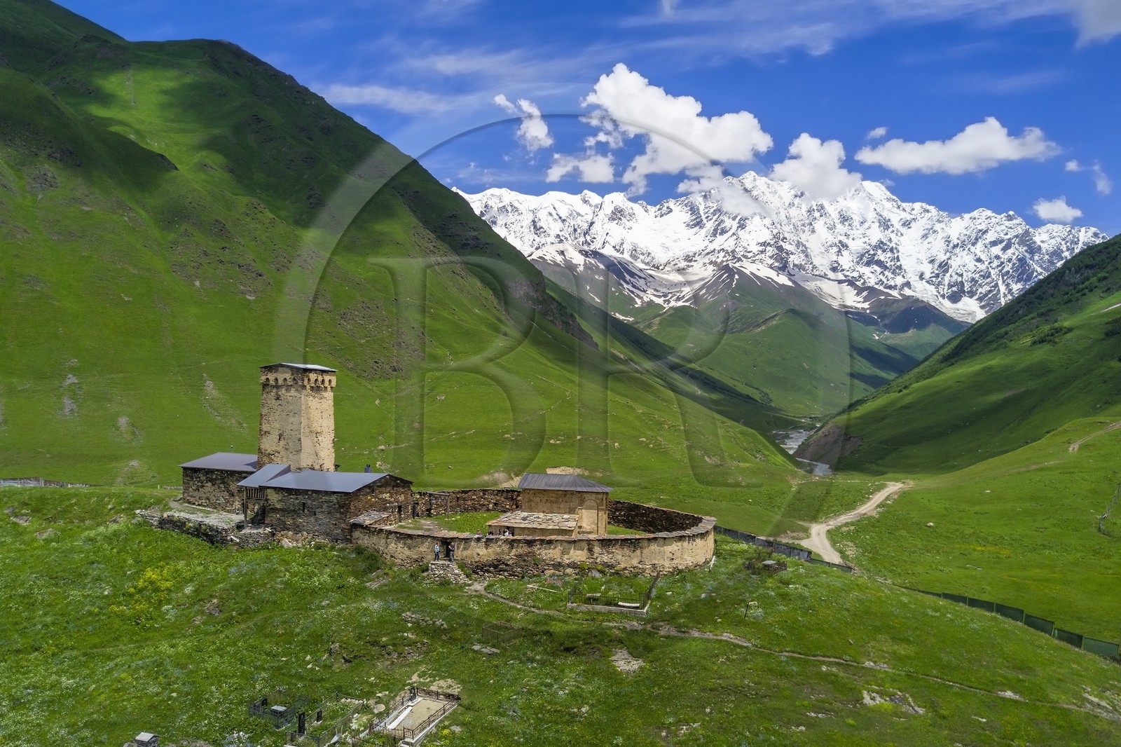 Georgia, Upper Svaneti (Zemo Svaneti), village of Ushguli, listed as World heritage by UNESCO, Lamaria St. Mary's church of Ushguli from the 12th century and Mount Chkhara (highest peak in Georgia with 5193 m) in the background (aerial view)