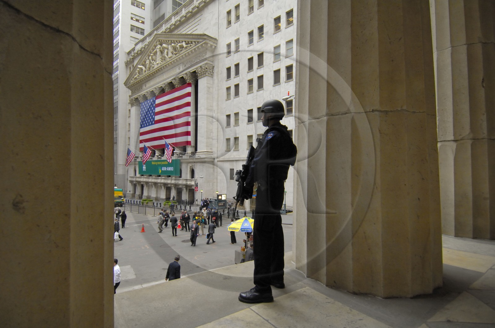 Etats-Unis, New York, Manhattan, policier lourdement armé montant la garde devant la bourse de Wall Street