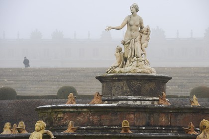 France, Yvelines (78), parc du château de Versailles, classé Patrimoine Mondial de l'UNESCO, statue de le Bassin de Latone dans la brume hivernale