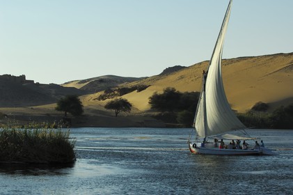 Egypt, Upper Egypt, Nile Valley, Aswan, felucca on the Nil and sand dunes of the western bank