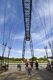 France, Charente-Maritime (17), Rochefort, le pont transbordeur de Rochefort (ou Martrou) construit par Ferdinand Arnodin en 1900, cycliste faisant la véloroute La Flow Vélo à bord de la nacelle en translation au dessus du fleuve Charente