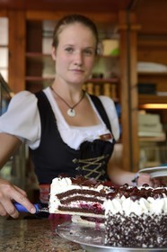 Allemagne, Bade-Wurtemberg, Durbach, Hotel Restaurant Rebstock, serveuse en costume traditionnel, gâteau Forêt Noire (Schwarzwälder Kirschtorte)