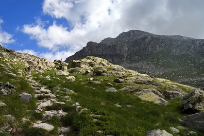 France, Alpes-Maritimes, parc national du Mercantour (Mercantour National Park), the Vallee des Merveilles (Valley of Wonders) scattered with thousands of rupestral engravings of the Bronze Age, hikers on the trail GR 52 and Mount Bego (2872m) in the background