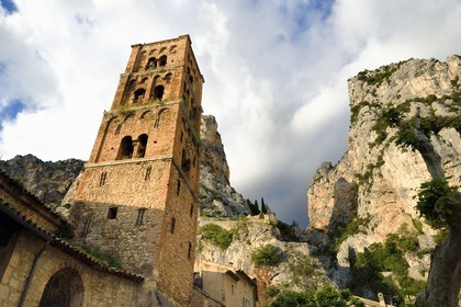 France, Alpes-de-Haute-Provence (04), Parc Naturel Régional du Verdon, Moustiers-Sainte-Marie, labellisé Les Plus Beaux Villages de France, l'église Notre-Dame-de-l'Assomption avec son clocher du XIIe siècle en tuff et l'Etoile de Moustier accrochée à une chaîne à plusieurs dizaines de mètres au-dessus du sol