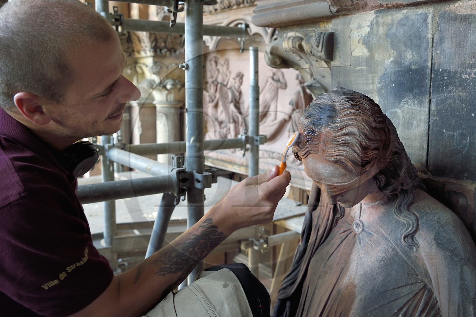 France, Bas-Rhin (67), Strasbourg, vieille ville classée au Patrimoine Mondial de l'UNESCO, la cathédrale Notre-Dame, chantier de restauration du Portail du Jour du jugement, nettoyage de la sculpture dite de la Synagogue à la brosse à dent par un compagnon tailleur de pierre