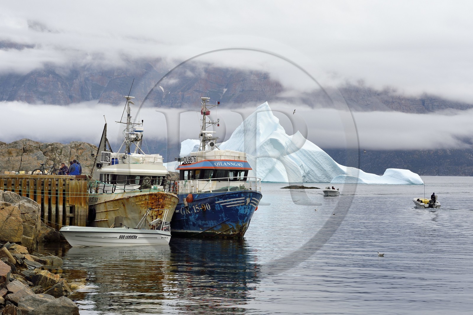 Groenland, cote ouest, Uummannaq, bateau de pêche dans le port et icebergs en arrière plan