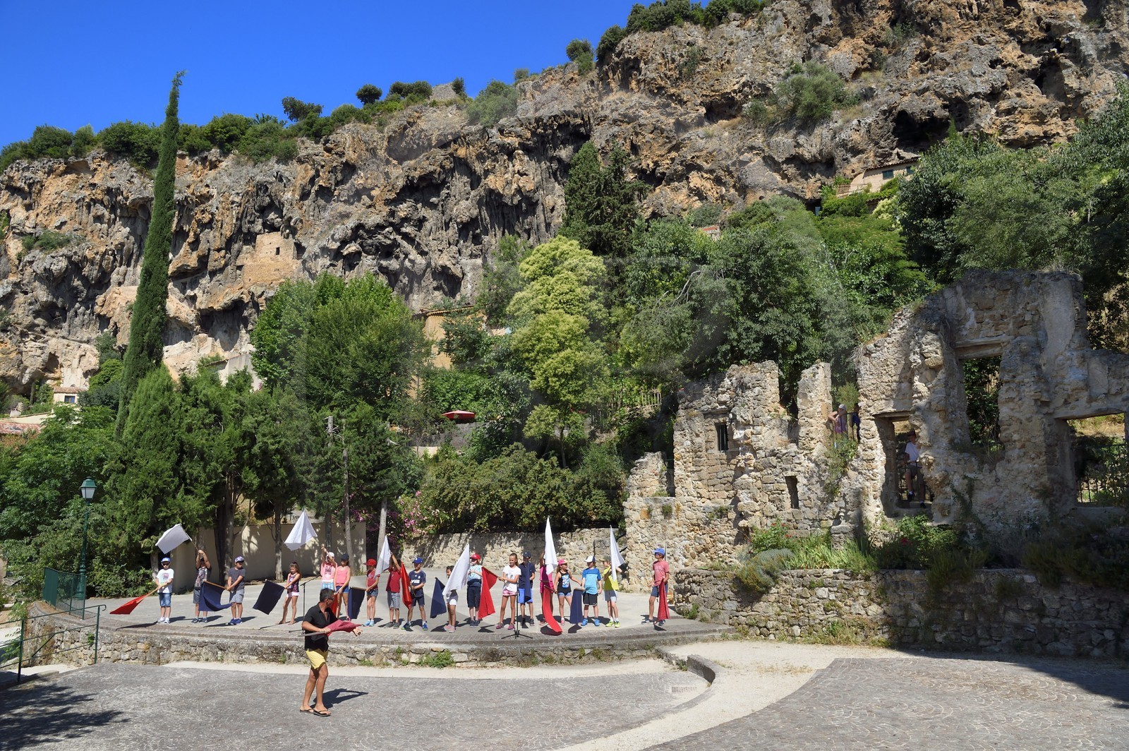 France, Var (83), Provence Verte, Cotignac, falaise de tuf de 80 mètres de haut et 400 mètres de large, enfants du village préparant un spectacle dans le théatre en plein air