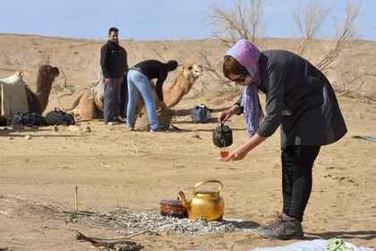 Iran, Province d'Ispahan, désert du Dasht-e Kavir, Mesr dans la région de Khur et Biabanak, randonnée chamelière, femme servant le thé à la pause de midi