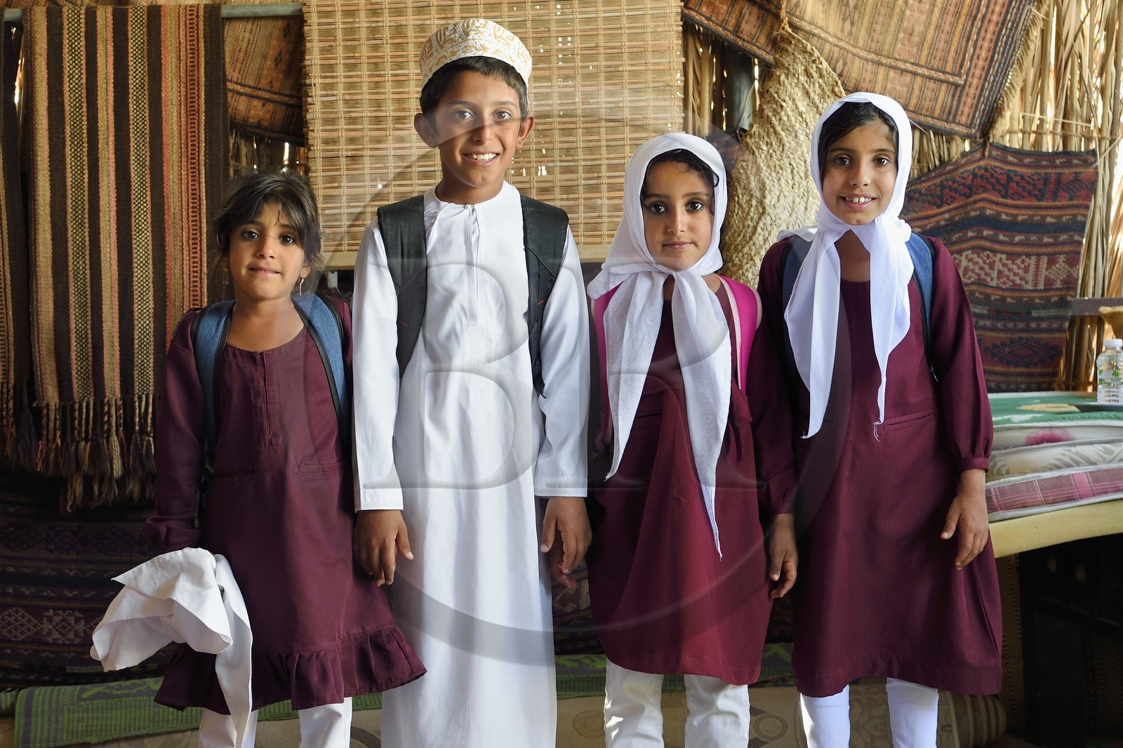 Sultanate of Oman, governorate of Ash Sharqiyah, desert of Wahiba Sands or Sharqiya Sands, Bedouin village of al-Wasil, al-Badri bedouin family, Nadjoua, Said, Assila and Nor coming home from school