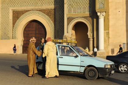 Maroc, Meknès, ville impériale, médina classée Patrimoine Mondial de l' UNESCO, taxi déposant ses clients devant la porte Bab el Mansour entre la cité impériale et la médina sur la place el Hédime ou Lahdim