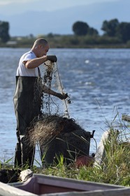 France, Haute Corse, the pond of Biguglia (Stagnu di Chiurlinu), nature reserve of Corsica (RNC), fisherman cleaning his net